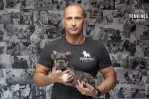 Tom holding a merle French Bulldog puppy